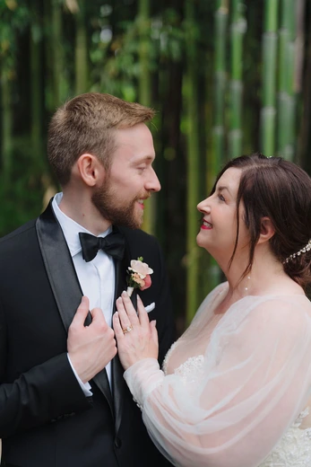 Bride and groom sharing a kiss in a bamboo grove