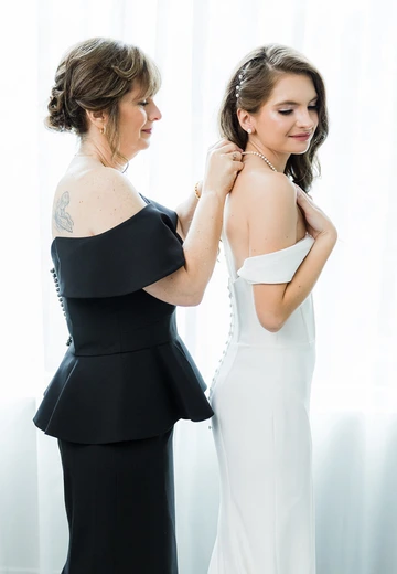 Bridesmaids in sage and cream dresses holding floral bouquets