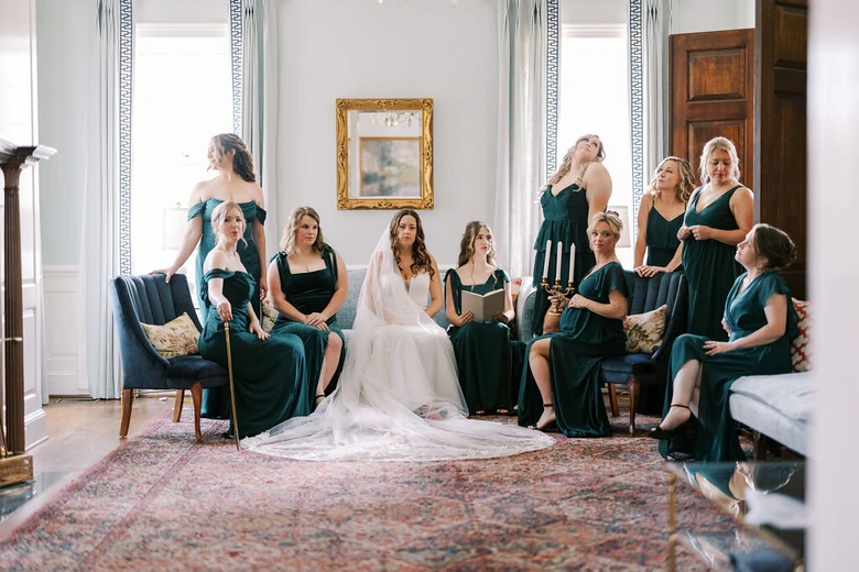 Bride and bridesmaids in emerald gowns in an editorial portrait