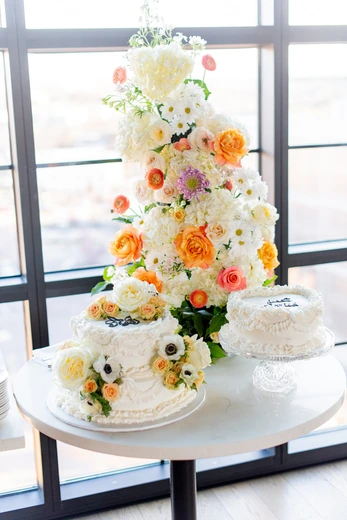 Two-tier wedding cake with cascading coral and pink florals